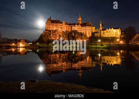 Il Castello Hohenzollern di Sigmaringen è situato direttamente sul Danubio, la luna piena accanto al castello si illumina le frazioni. Foto Stock