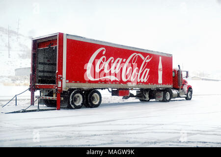 Un rosso coca-cola carrello pop di scarico in corrispondenza di una stazione di gas nella neve. Foto Stock