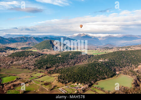 Mongolfiera Volare con Croscat vulcano aperto e le montagne sullo sfondo, giorno nuvoloso, Olot, Catalogna, Spagna Foto Stock