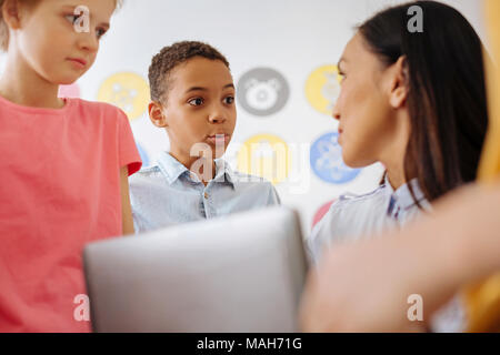 Carino boy comunicante con il suo maestro dopo le lezioni Foto Stock