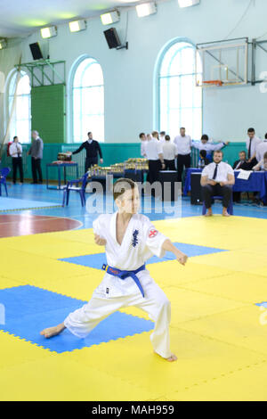 La concorrenza tra i bambini nel karate,kata.10-11 anno vecchio ragazzo esegue nel karate kyokushin competizioni, egli fa kata, zenkutsu-dati stand Foto Stock