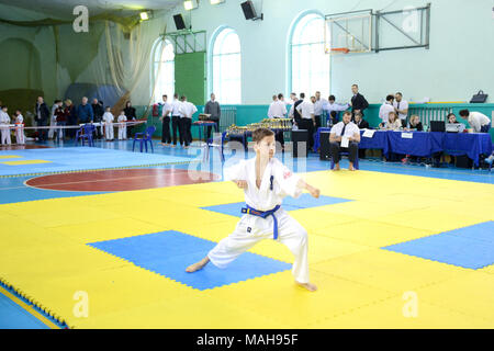 La concorrenza tra i bambini nel karate,kata.10-11 anno vecchio ragazzo esegue nel karate kyokushin competizioni, egli fa kata, zenkutsu-dati stand Foto Stock