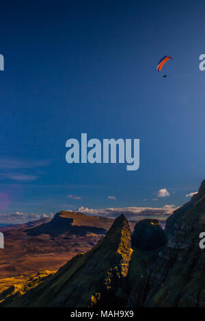 Parapendio sopra le scogliere di Trotternish Ridge e la Quiraing, Isola di Skye Foto Stock