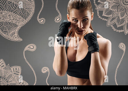 Fiducioso fighter cercando seria mentre stringendo la sua a suon di pugni Foto Stock