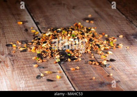 Bird seme sparso su un tavolo di legno Foto Stock