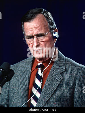 Camp Greentop, Maryland, Stati Uniti d'America, 25 febbraio 1990 il presidente George H.W. Bush usa un auricolare per l'ascolto di brani di un traduttore nel corso di una conferenza stampa congiunta con il cancelliere tedesco Helmut Kolh appena fuori a Camp David Credito: Mark Reinstein/MediaPunch Foto Stock