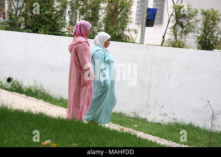 Due signore a piedi al di fuori di Tangeri vestito in un colorito tradizionale abbigliamento islamico Foto Stock