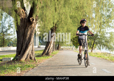 Senior donna asiatica di una bicicletta Foto Stock