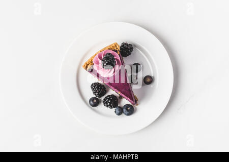 Vista superiore della torta ai mirtilli con frutti di bosco freschi sulla piastra isolata su bianco Foto Stock