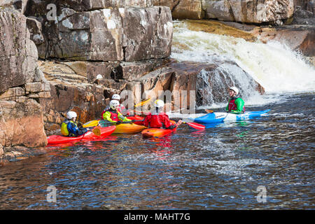 Gruppo di adolescenti formazione in kayak sul fiume Etive Falls, Glencoe, Highlands scozzesi, Scotland, Regno Unito in Marzo Foto Stock