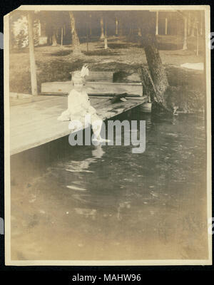 Titolo: Mildred Frances Lyon Dondolando i suoi piedi nel lago in corrispondenza della sua famiglia estate home. . Circa 1905. Foto Stock