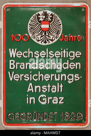 Premuto lo stagno di fuoco per mark Wechselseitige Brandschaden Versicherungs Anstalt in Graz da Graz, Austria mostra emblema di eagle nel cerchio in alto con il rosso e bianco di scritte, tutte sollevate su sfondo verde Titolo: Fire mark per Wechselseitige Brandschaden Versicherungs Anstalt in Graz da Graz, Austria . dopo il 1829. Foto Stock