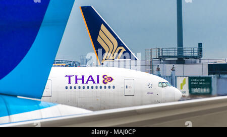 Due jetliner tails incornicia un Thai Airways jetliner Foto Stock