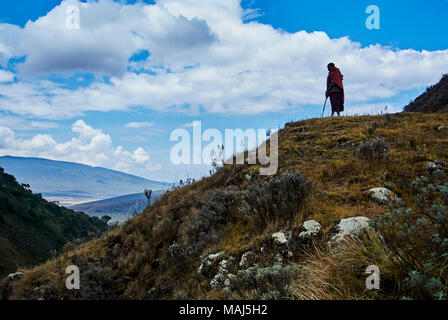 Escursione nel cratere di Olmoti, vicino al fiume Munge Ngorongoro Conservation Area parco Nationnal Highlands con guida Masai indossando tradizionale coperta di rosso Foto Stock