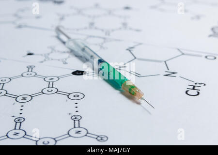 Concetto di Non-prodotti naturali, ogm. Siringa su sfondo bianco con formula chimica, Foto Stock