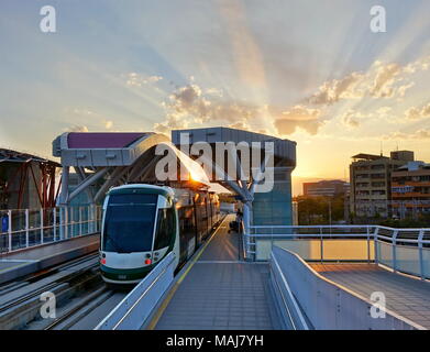 KAOHSIUNG, Taiwan -- Marzo 2, 2018: un treno di il nuovo sistema di ferrovia leggera di tira nell'amore stazione molo al tramonto del tempo. Foto Stock