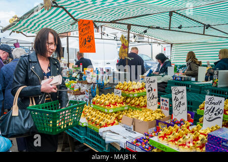 Donna acquistare a basso prezzo di marca di cioccolato Lindt conigli pasquali da un mercato in stallo nel North Yorkshire Foto Stock