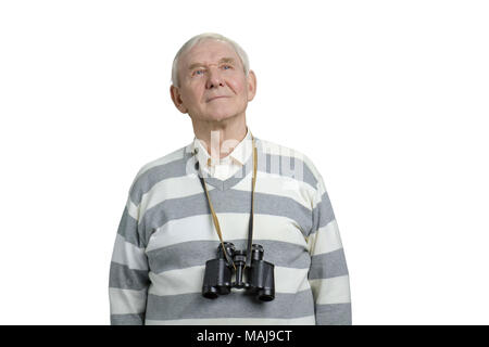 L'uomo anziano con il binocolo guarda in alto. Vecchio tourist osservando la posizione. Bianco sfondo isolato. Foto Stock