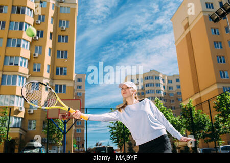 Donna giocando a tennis all'aperto Foto Stock