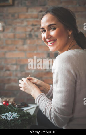 Ragazza perfetta realizzazione decorazioni di Natale a casa Foto Stock