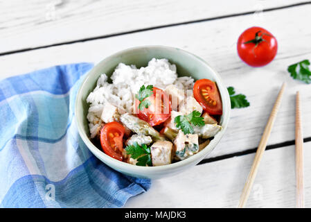 Delizioso piatto di tofu in una terrina con il pomodoro fresco, riso e prezzemolo. Cibo Vegan o vegetariano. veggie mangiare. Foto Stock