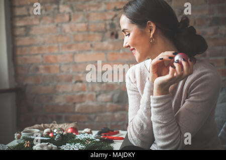 Bella giovane donna con decorazioni di Natale a casa Foto Stock