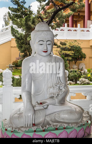 Hacienda Heights, CA, Stati Uniti d'America - 23 Marzo 2018: statua bianca del secolo dei lumi del Buddha sul lato del giardino con lotus piedistallo a Hsi buddista Lai Foto Stock