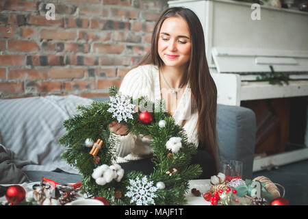 Ragazza carina con decorazioni di Natale a casa Foto Stock