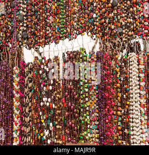 Stringhe di perline colorate in un mercato locale come una texture di sfondo Foto Stock