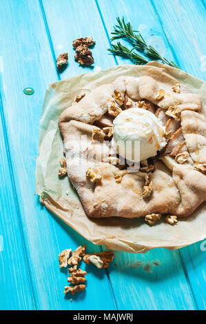 Torte fatte in casa con pere e gelati su blu sullo sfondo di legno. Foto Stock