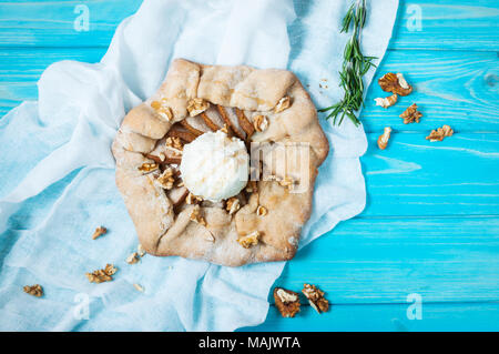 Torte fatte in casa con pere e gelati su blu sullo sfondo di legno. Foto Stock
