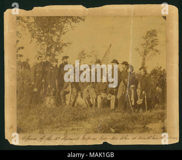 Foto di gruppo di 14 unione ufficiali in uniforme con il tamburo in primo piano e bandiera in background. 'Ufficiali del 3d reggimento volontari Missouri prese a Corinto Miss Oct 20th 1863' (scritta immagine sotto). Titolo: 'ufficiali del terzo reggimento volontari Missouri prese a Corinto, Mississippi, 28 ottobre 1863.' . Il 28 ottobre 1863. Foto Stock