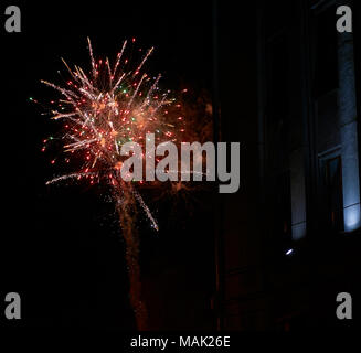 Colorate di rosso brillante fuochi d'artificio e fumo nel cielo notturno di close-up sfondo con una copia spazio Foto Stock