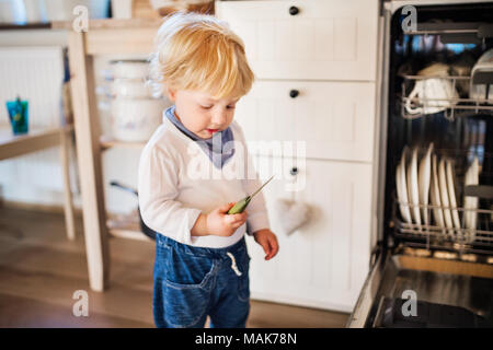 Il Toddler boy in situazione di pericolo a casa. Bambino il concetto di sicurezza. Foto Stock