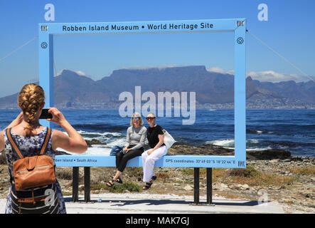 I turisti per scattare delle foto di Robben Island, off Cape Town, il sito Patrimonio Mondiale dell'UNESCO, e tristemente famoso per il suo più famoso prigioniero Nelson Mandela. Foto Stock