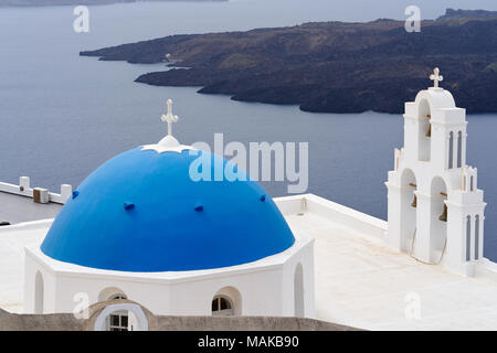 Santorini iconici blue-cupola chiesa con isola e mare come sfondo, una delle famose localita turistica di Oia - Santorini in Grecia. Foto Stock