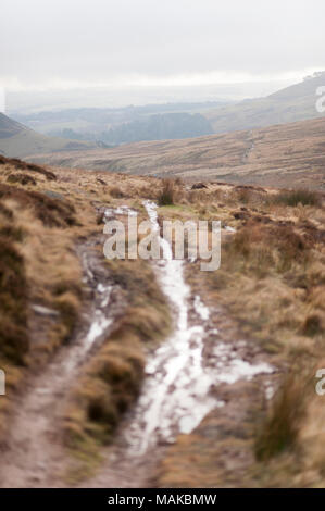 Un sentiero fangoso che corre attraverso le colline. Foto Stock