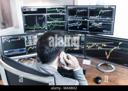 Al di sopra della spalla vista di schermi di computer e stock broker trading online. Foto Stock
