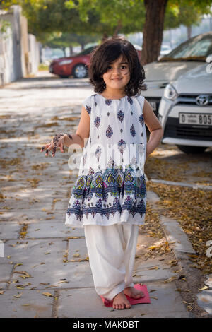 Una bambina in posa per il servizio fotografico indossando il tradizionale pakistano/Afhani abito e che mostra la sua mano tatuati con henné, chiamato anche Mehndi. Foto Stock