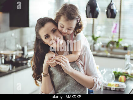 Ritratto di un simpatico figlia abbracciando la sua amata madre Foto Stock