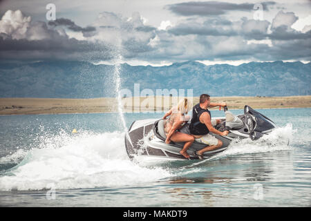 Coppia giovane sul jet ski, mare Adriatico, Croazia. Calore estivo, active sport e ricreazione, vacanza e divertimento in spiaggia. Foto Stock