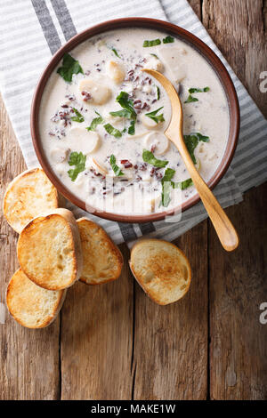 Zuppa calda di riso selvatico con funghi e verdure close-up e toast sul tavolo. Verticale in alto vista da sopra Foto Stock