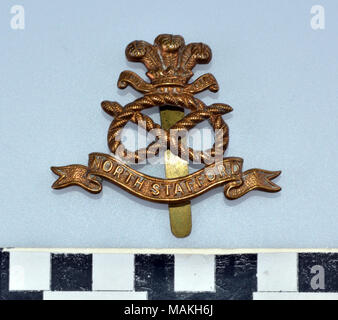 La prima guerra mondiale a nord di Staffordshire ottone reggimento hat distintivo costituito da una corda annodata sormontato dal Principe di Galles di piume overa banner goffrato North Stafford Titolo: I Guerra Mondiale Nord Staffordshire Reggimento Hat monogramma . dopo il 1914. Foto Stock