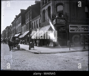 In orizzontale e di fotografia in bianco e nero che mostra il lato nord di Franklin Avenue, guardando ad ovest dalla 19th Street. Vista mostra una varietà di negozi e di edifici commerciali, compresi Temm's Drug Store all'angolo a 1901 Franklin. Un cavallo disegnato carro è sulla sinistra e molti pedoni stanno camminando lungo il marciapiede. Titolo: lato nord di Franklin, guardando ad ovest dalla 19th Street, compresi Temm's Drug Store a 1901 Franklin. . Tra 1900 e 1910. Foto Stock