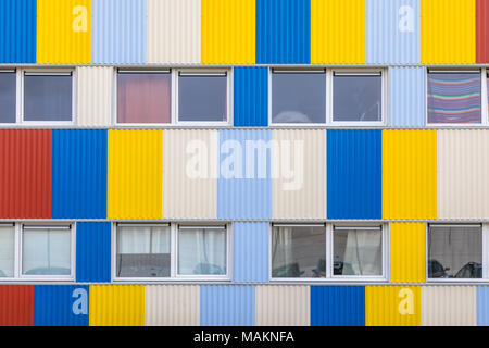 Finestre delle case dello studente in contenitori di spedizione dipinte in colori pright con parcheggio per le bici in primo piano Foto Stock