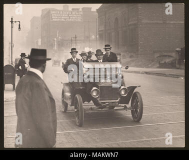 In orizzontale e di fotografia in bianco e nero di un gruppo di uomini e una donna prendendo un azionamento in una automobile Jitney. Titolo: quattro uomini e una donna prendendo un $.05 ride in una automobile Jitney al diciottesimo e locusta. . Circa 1900. Swekosky, William G., 1895-1964 Foto Stock