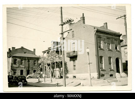 In orizzontale e di fotografia in bianco e nero a tre piani in mattoni residence con base in pietra. Un balcone è visibile sul lato sinistro del residence e un'aggiunta è presente sul lato posteriore. La parte posteriore presenta una costruzione a due piani con portico di una scala in legno e finestre dormer. Titolo: Schotten, William Residence. Tredicesima e Hickory angolo sud-ovest. . Tra circa 1900 e circa 1940. Swekosky, William G., 1895-1964 Foto Stock