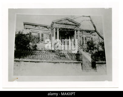 In orizzontale e di fotografia in bianco e nero di una storia di revival greco di pietra in stile residence con scalinata che conduce al portico anteriore. Un frontone triangolare è al di sopra del portico anteriore e sostenuto da colonne ioniche. Ante Telaio ciascuna finestra e due donne e un uomo e un bambino in piedi sulla parte anteriore portico. Titolo: Mincke, George Residence. 1709 Chouteau. . Tra circa 1870 e circa 1900. Swekosky, William G., 1895-1964 Foto Stock