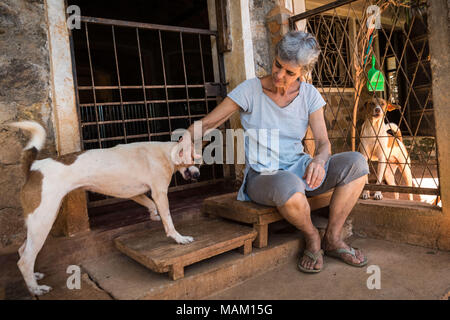 Kandy, Sri Lanka. Il 21 febbraio, 2018. EVA RUPPEL siede alla sua porta anteriore sulla sua proprietà rurale vicino a Kandy, Sri Lanka, mercoledì 21 febbraio, 2018. Ruppel non gabbia approssimativamente 170 salvato cani, consentendo loro la libertà per interagire in piccole confezioni di penne multiple in tutta la sua proprietà, come pure all'interno di lei a casa. Ruppel creato Tikiri Trust, con il contributo finanziario di suo padre, di salvataggio e rehome Sri Lanka di cani randagi.It è possibile visitare lo Sri Lanka senza vedere i cani di strada in quasi ogni spazio pubblico, vicino ad alberghi, pensioni e ristoranti, scuole, uffici, Foto Stock