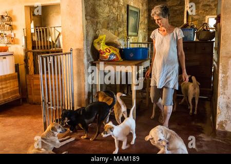 Kandy, Sri Lanka. Il 21 febbraio, 2018. EVA RUPPEL passeggiate con un piccolo pacco di soccorrere i cani dentro la sua casa nei pressi di Kandy, Sri Lanka, mercoledì 21 febbraio, 2018. Ruppel non gabbia approssimativamente 170 salvato i cani vivono con lei, consentendo loro la libertà di spostarsi e di interagire in piccole confezioni di penne multiple in tutta la sua proprietà, come pure all'interno di lei a casa. Ruppel creato Tikiri Trust, con il contributo finanziario di suo padre, di salvataggio e rehome Sri Lanka di cani randagi.It è possibile visitare lo Sri Lanka senza vedere i cani di strada in quasi ogni spazio pubblico, vicino ad alberghi, guest house Foto Stock